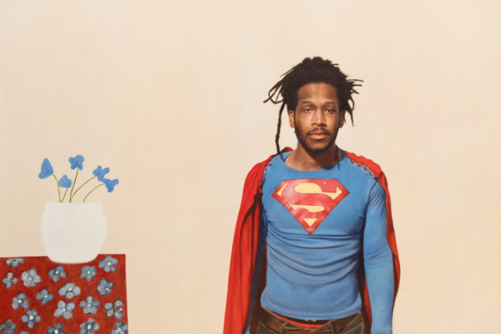 Junger, schwarzer Mann im Superman-Kostüm
