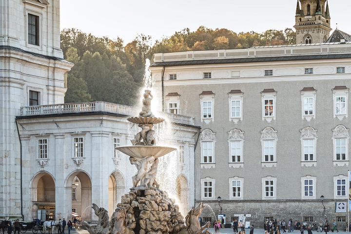 Alte Gebäude auf einem Platz mit einem Zierbrunnen.