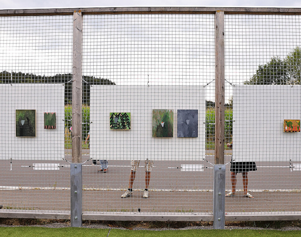 Zaun mit darauf aufgehängten Bildern