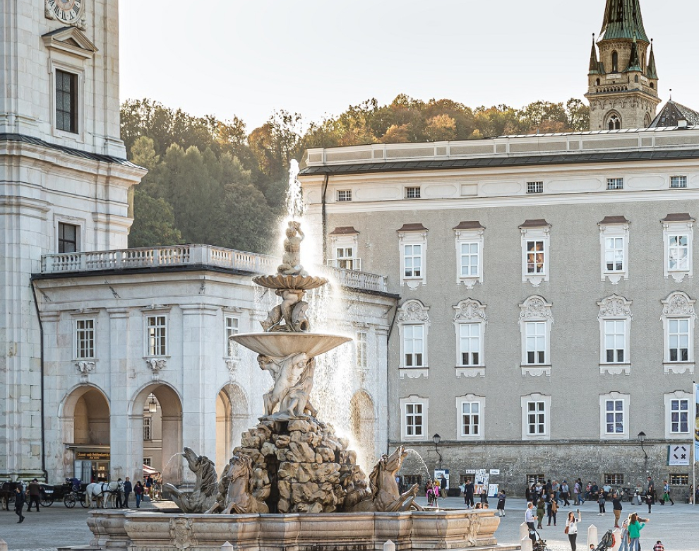 Alte Gebäude auf einem Platz mit einem Zierbrunnen.